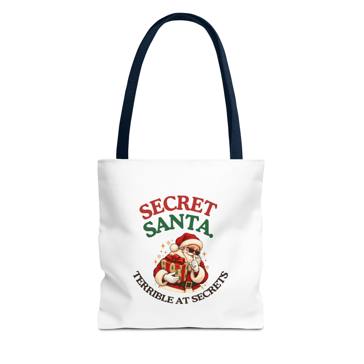 A white tote bag with navy handles featuring the “Secret Santa. Terrible at Secrets.” design on a white background