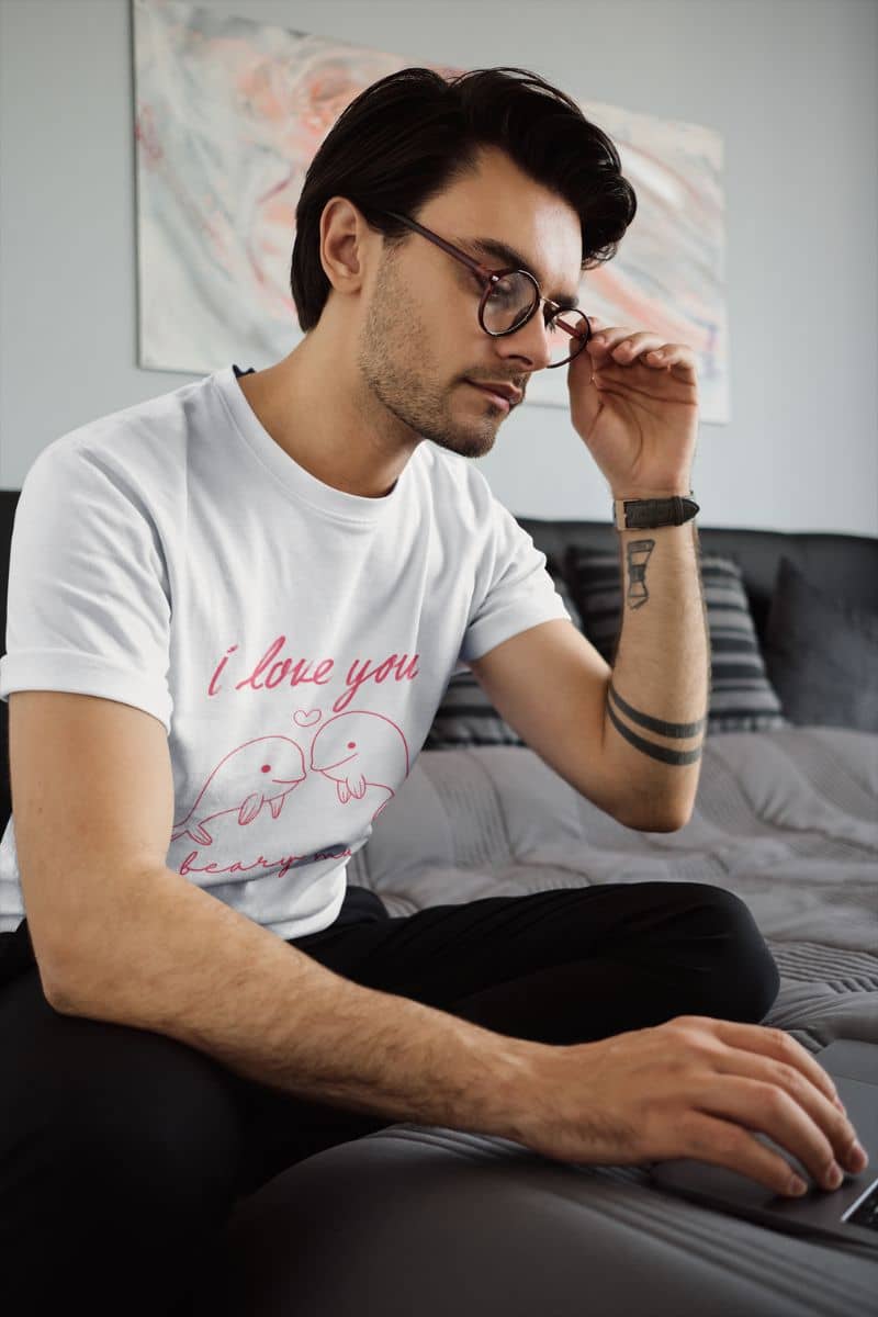 Adorable Dolphin love t-shirt with a guy wearing glasses sitting working on his laptop on his bed