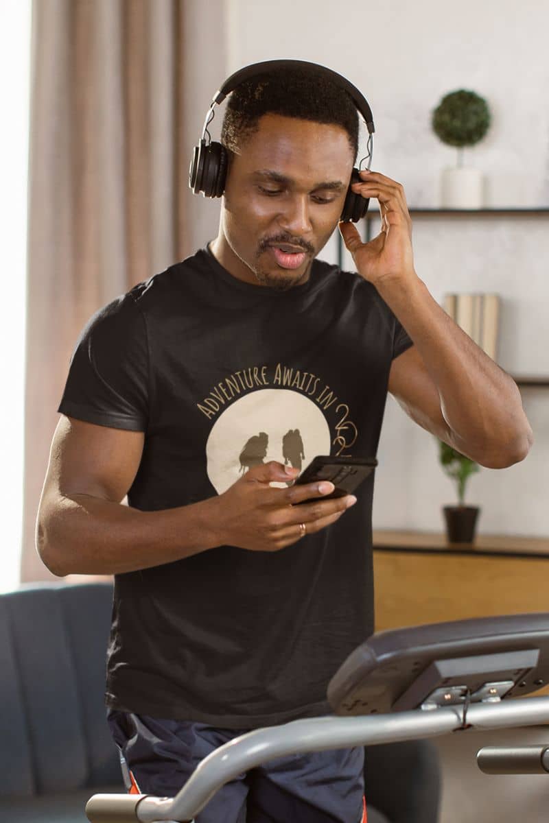 Adventure Awaits in 2025 T-Shirt with a guy listening to music on a treadmill