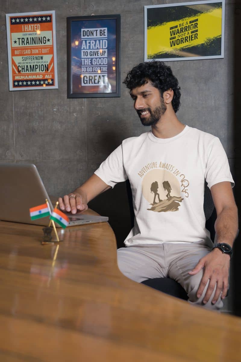 Adventure Awaits in 2025 T-Shirt with a guy working at a cafe