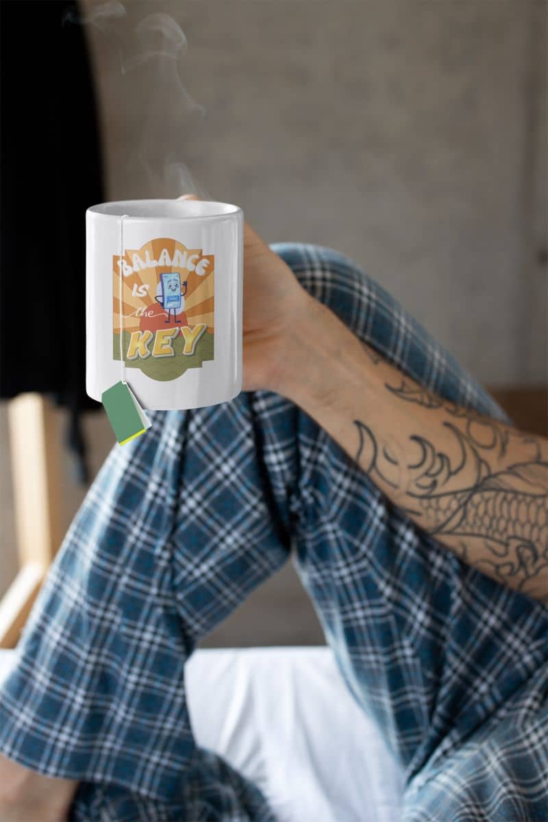 Balance is the key mug with a man holding a cup of hot tea on the bed