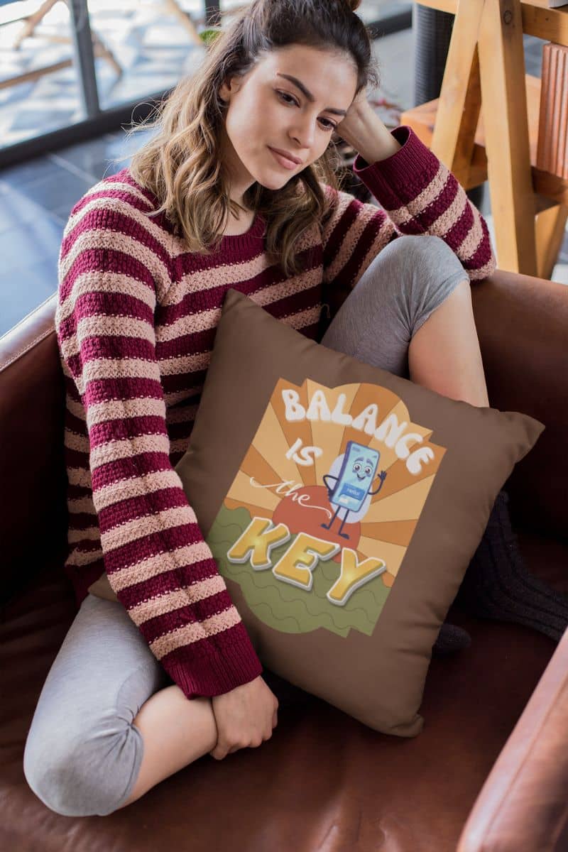 Balance is the key pillow with the girl sitting on the sofa in deep thought, hugging a large pillow to her chest