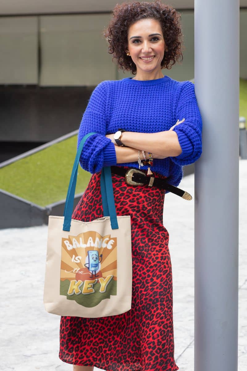 Balance is the key tote bag with a stylishly dressed middle-aged woman posing next to a roadside pillar