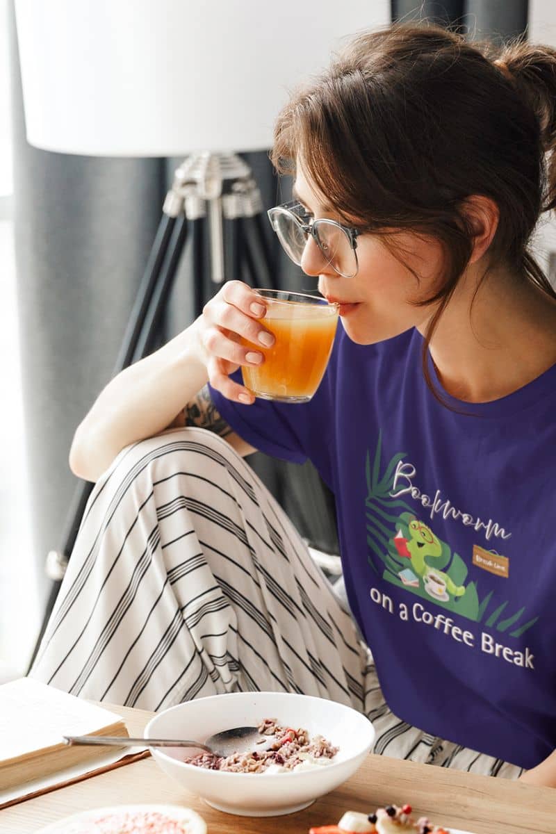 Bookworm coffee break t-shirt with a girl sitting at the dining table eating breakfast and reading a book