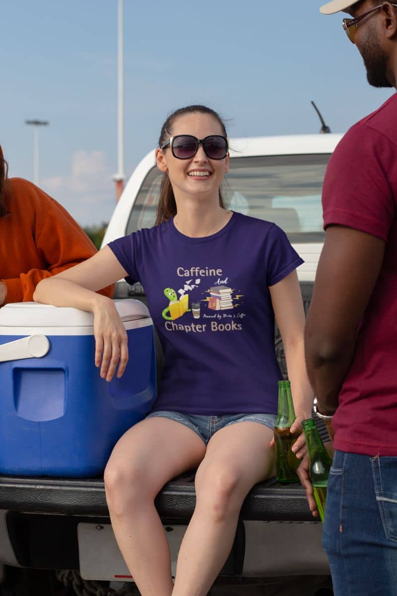 Bookworm fuel t-shirt with girl talking to friends while sitting on the floor of a pickup truck