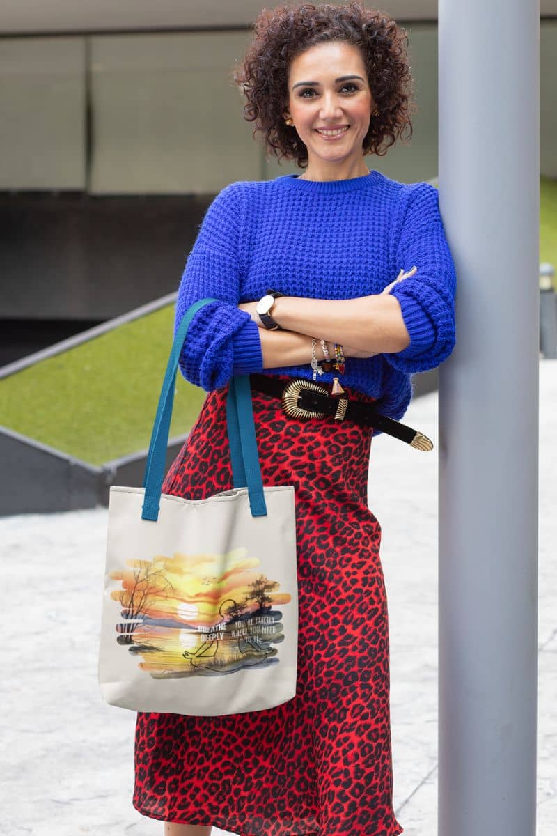 Breathe Deeply Tote Bag with an elegant woman leaning against a pillar with a radiant smile
