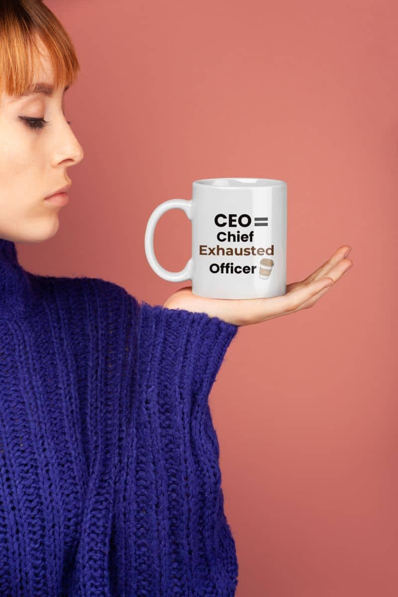 Caffeine lover mug with a person holding a mug with text 'CEO = Chief Exhausted Officer' against a pink background
