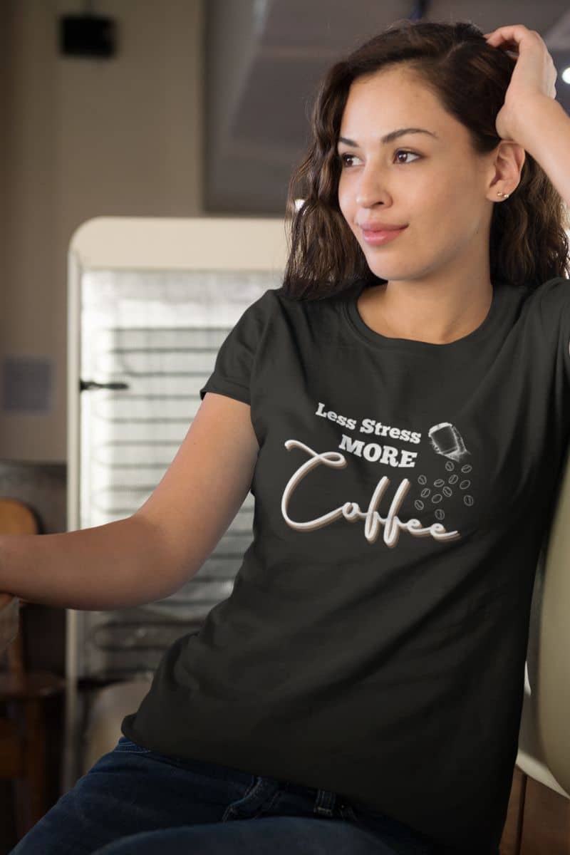 Coffee lover t-shirt with a girl sitting pensively, one hand holding a cup of coffee on the table and the other supporting her head