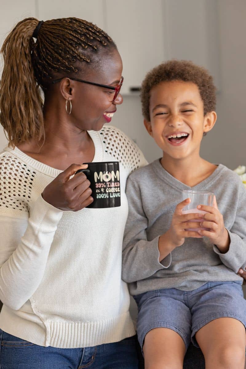Coffee mug for moms with a woman holding her son with a loving look while still holding a cup of coffee
