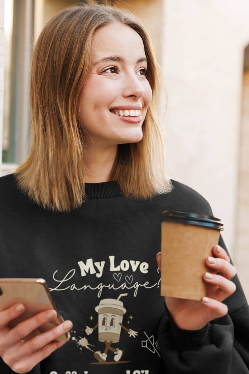 Comfy coffee sweatshirt with a pretty girl holding a cup of coffee and a phone on her hand with a bright smile