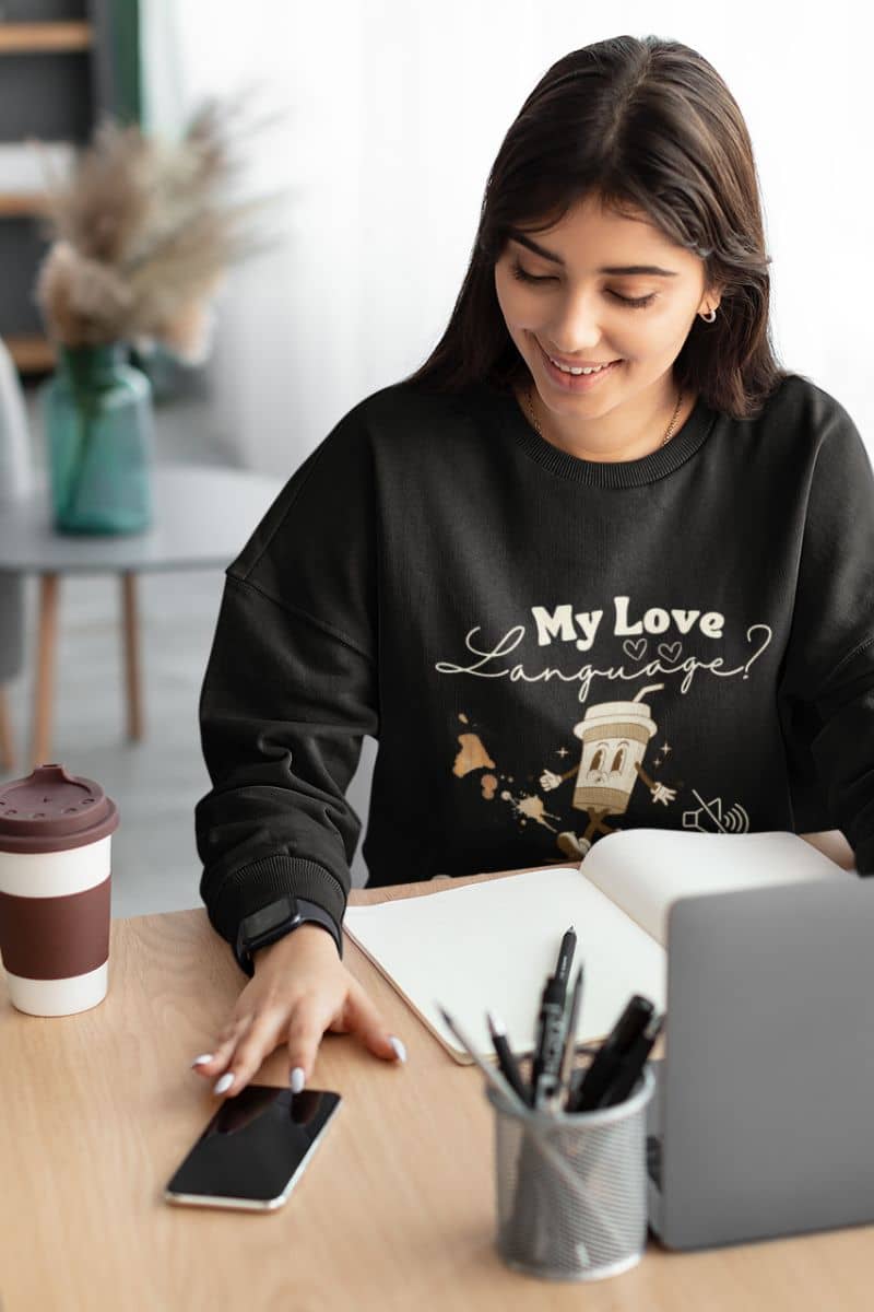Comfy coffee sweatshirt with a pretty girl working next to a cup of coffee on the table