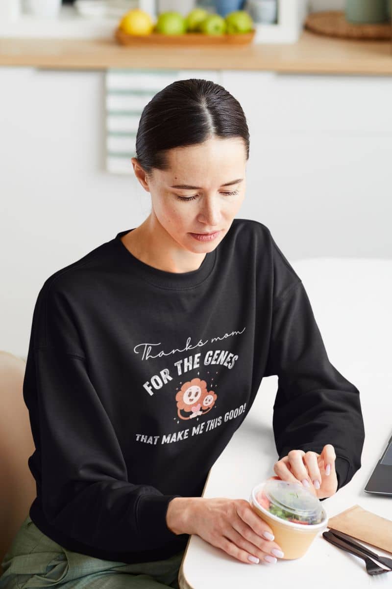 Cool sweatshirt with a girl opening a salad container on the table