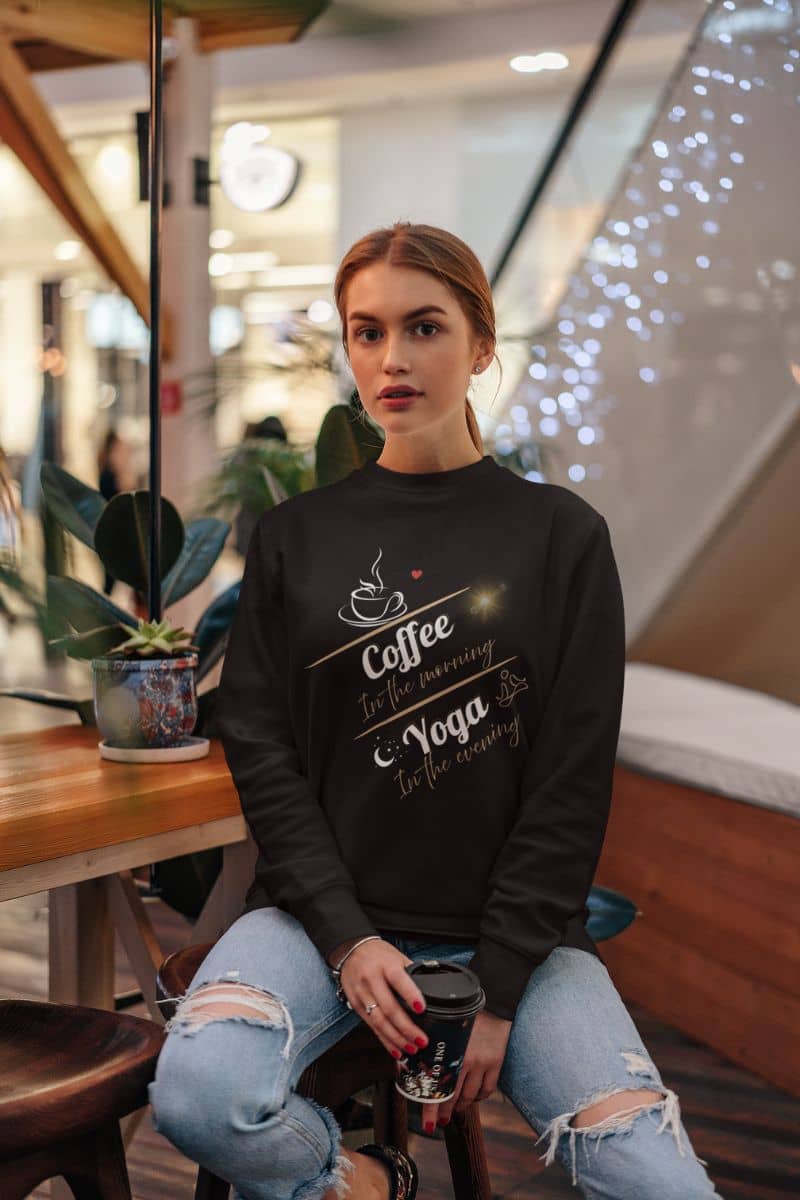 Cozy pullover sweatshirt with a young girl holding a cup of coffee in a shopping mall