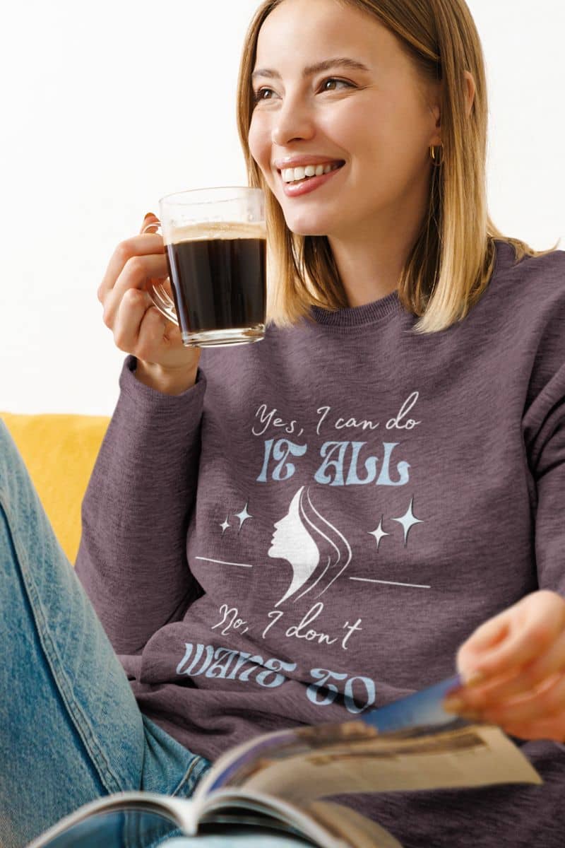 Cozy sarcastic sweatshirt with a girl reading a book and smiling brightly with a cup of coffee in her hand
