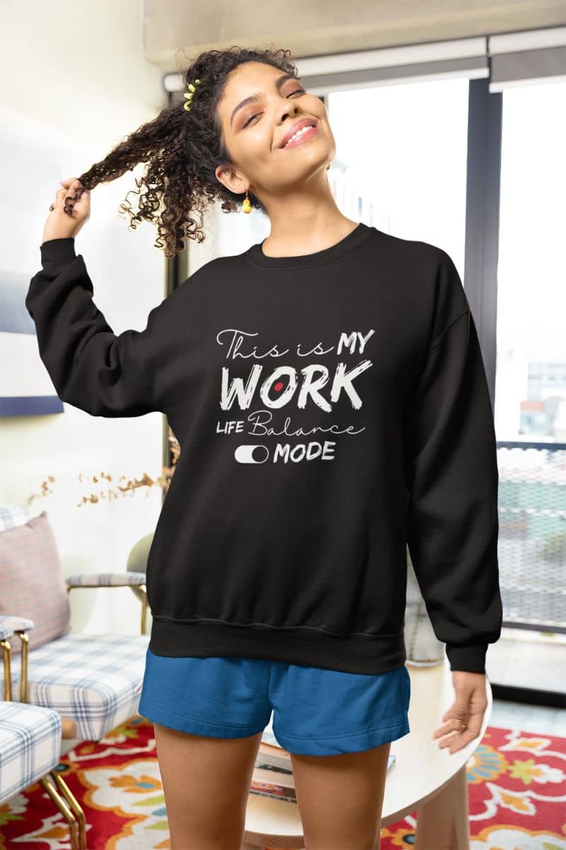 Cozy work-life balance sweatshirt with a girl posing by pulling her hair back while at home