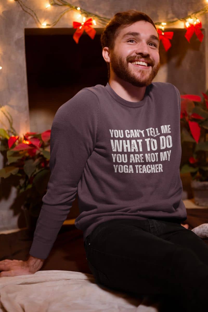 Empowering yoga  sweatshirt with a guy sitting on the sofa in a room decorated for Christmas with a big smile