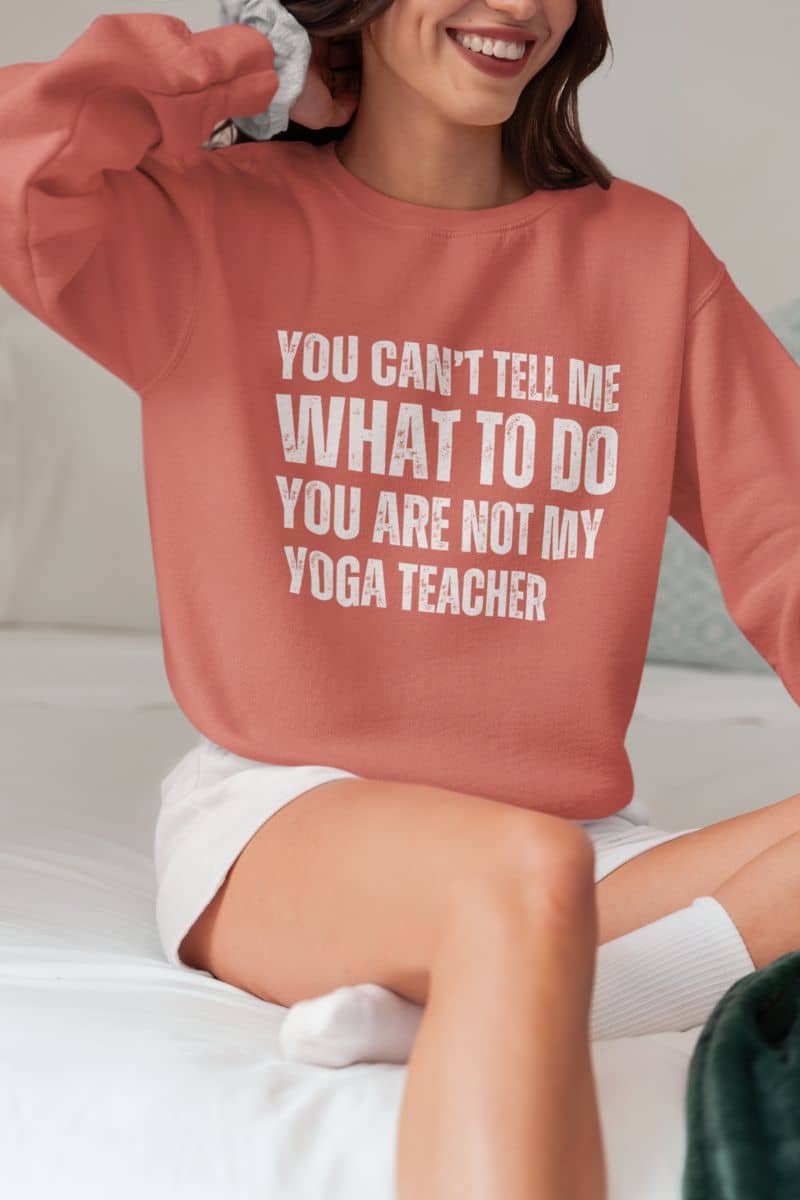 Empowering yoga  sweatshirt with the girl sitting on the bed and smiling brightly