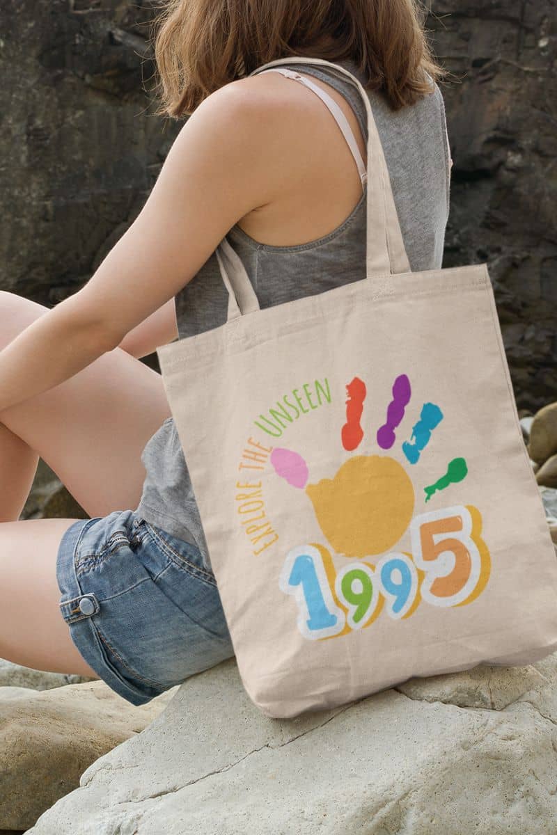 Explore the Unseen 1995 Tote Bag with the girl sitting on a rock looking out to sea