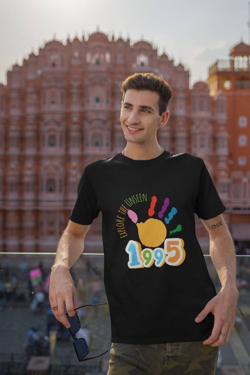 Explore the unseen t-shirt with a guy leaning on a balcony taking pictures at a major tourist destination