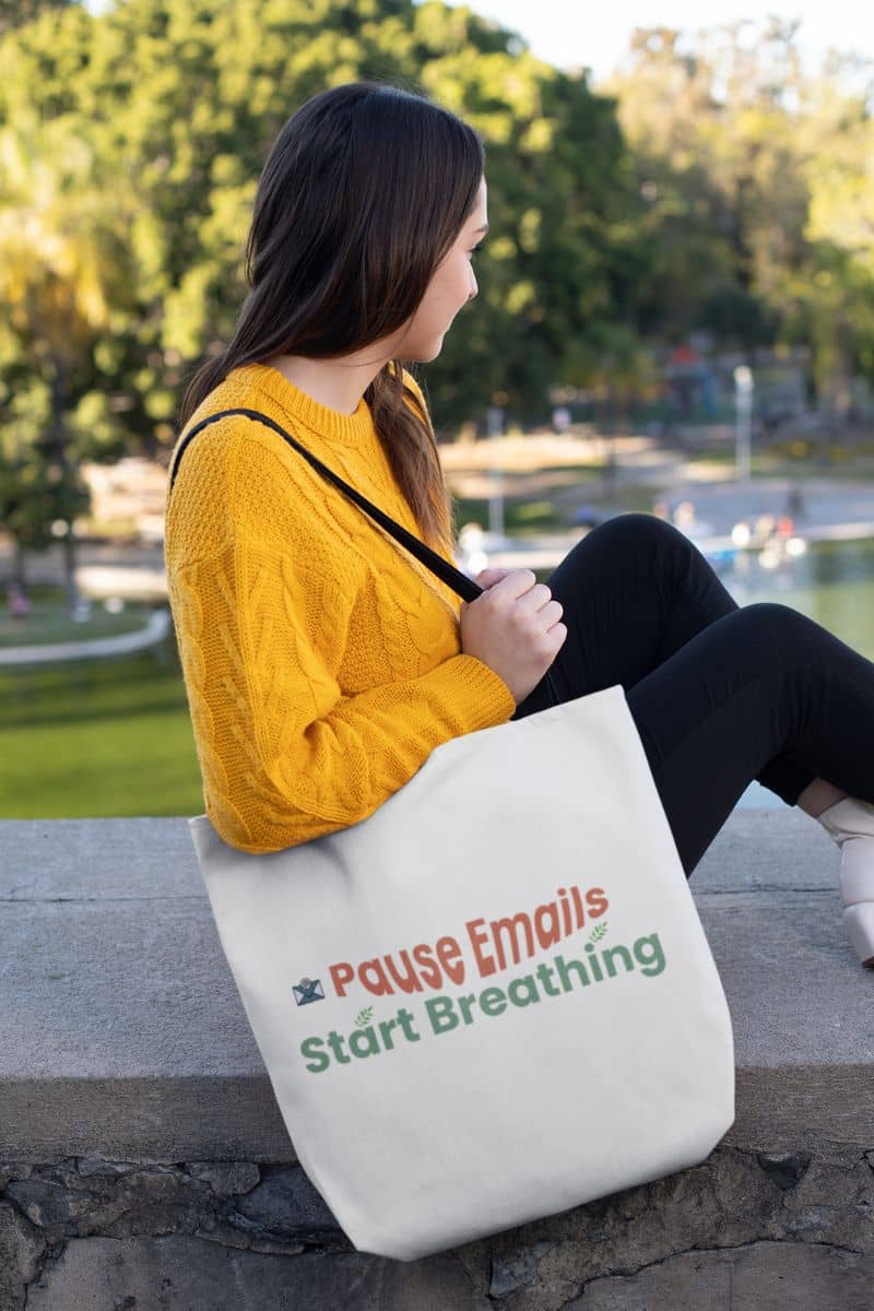 Feminine empowerment bag with a woman holding a tote bag with text in a park setting