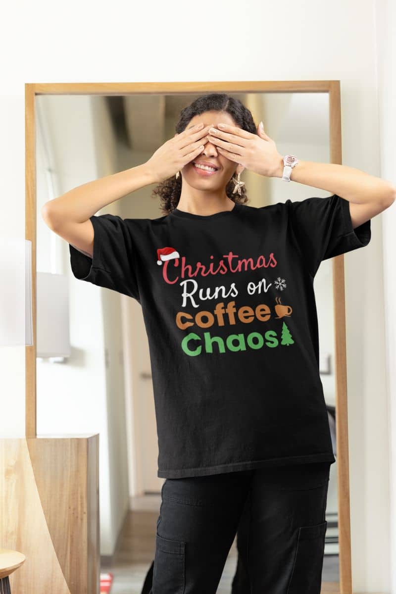 Festive holiday shirt with a person wearing a black t-shirt with text 'Christmas Runs on Coffee & Chaos'