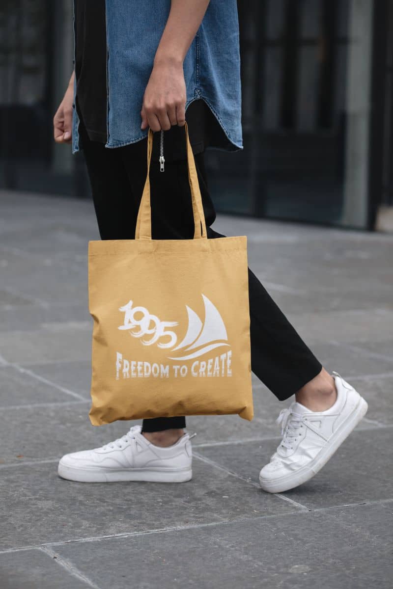 Freedom to Create Tote Bag with the guy holding a tote bag walking down the street