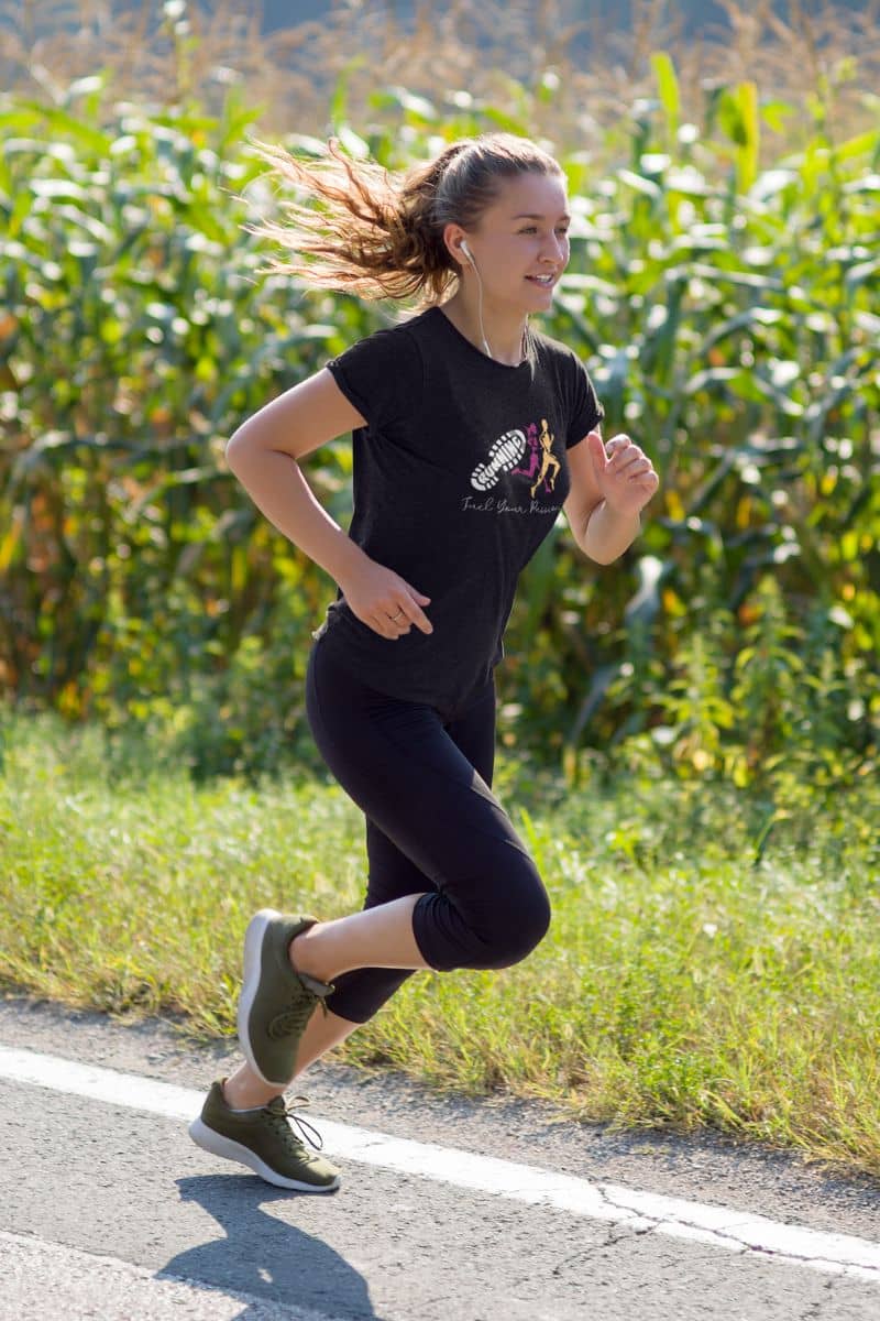 Fuel Your Passion T-Shirt with a girl wearing headphones while jogging