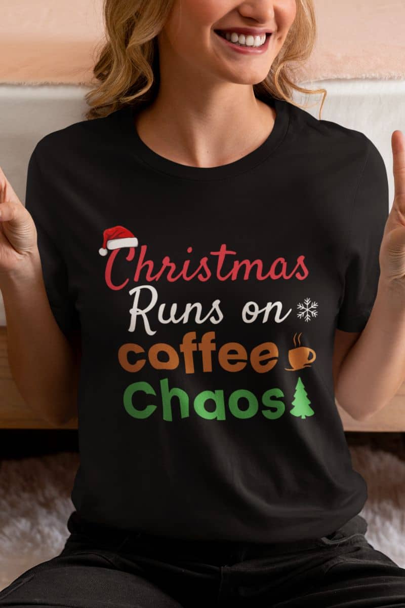 Funny coffee Christmas shirt with a person wearing a black t-shirt with text 'Christmas Runs on Coffee & Chaos'