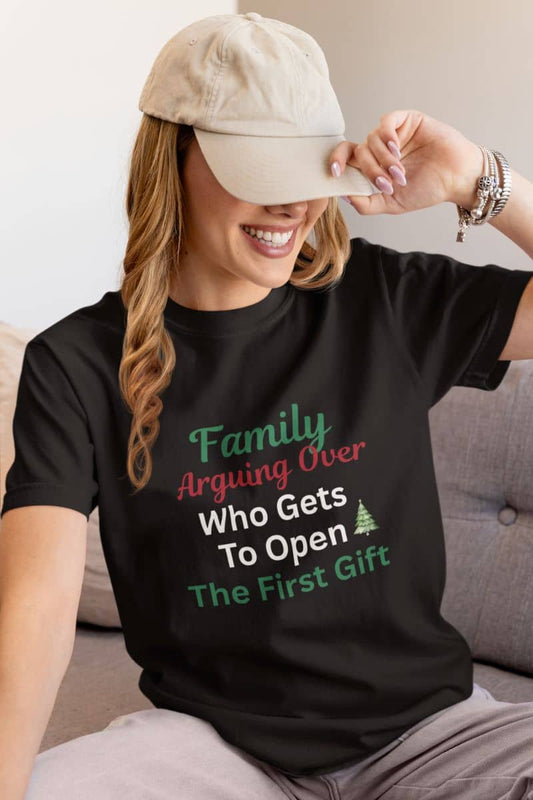 Funny family Christmas t-shirt with a person wearing a black t-shirt with humorous text, sitting on a couch.