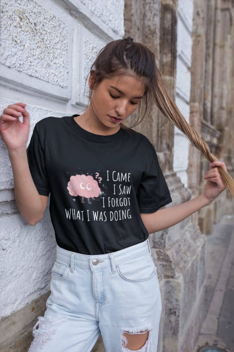 Funny graphic t-shirt with a girl leaning against the wall posing with her ponytail