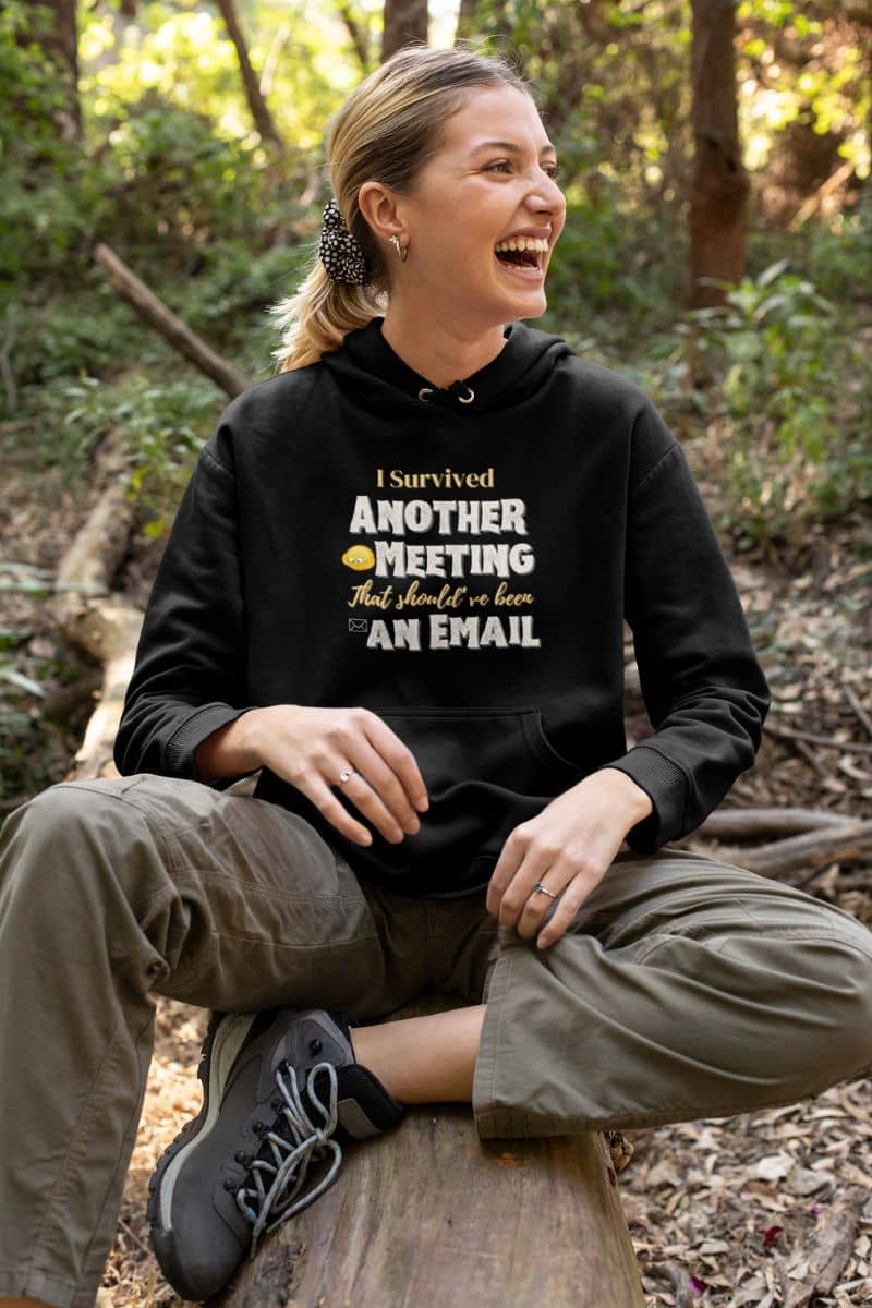 Funny hoodie with the girl sitting on the dry tree with a bright smile and looking in one direction
