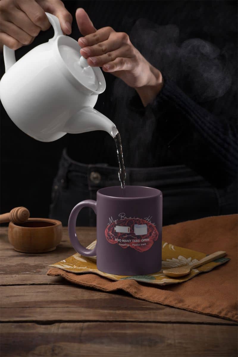 Funny mental overload coffee mug with a woman pouring hot tea into a cup