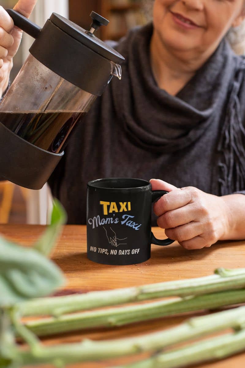 Funny mom's taxi coffee mug with a middle-aged woman pouring coffee into a cup