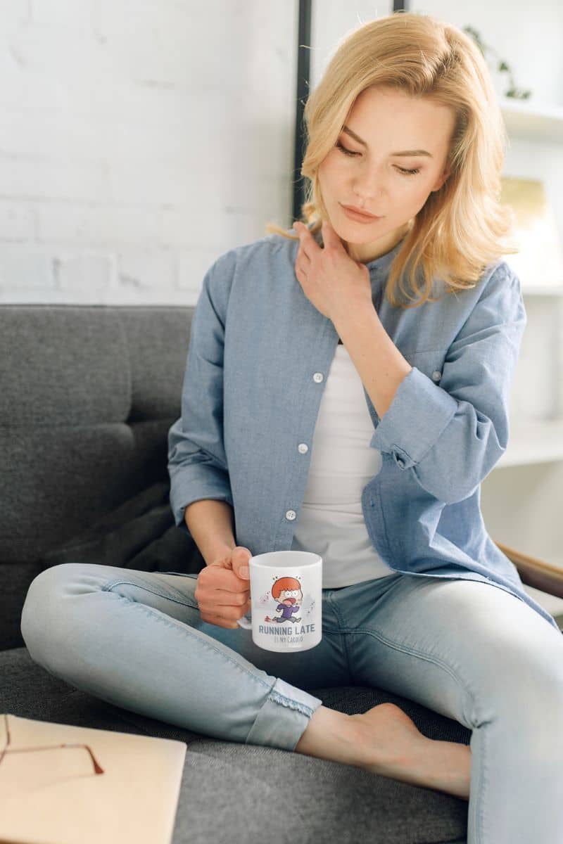 Funny running mug with a girl sitting on the sofa with a pensive look on her face while holding a cup in her hand