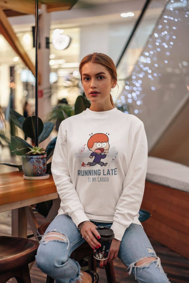 Funny running sweatshirt with a beautiful girl sitting in a corner of the coffee shop and holding a cup of coffee posing