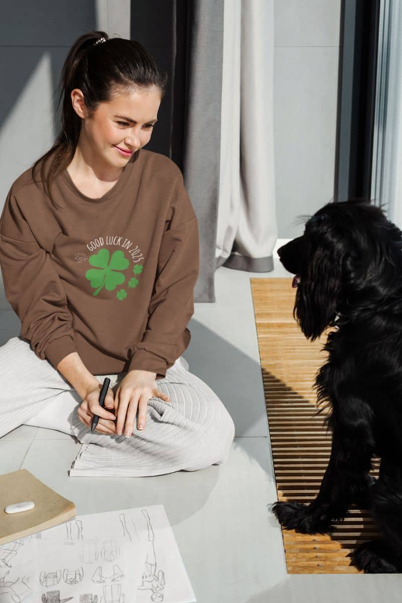 Good luck in 2025 sweatshirt to the girl sitting on the floor drawing and smiling at her dog