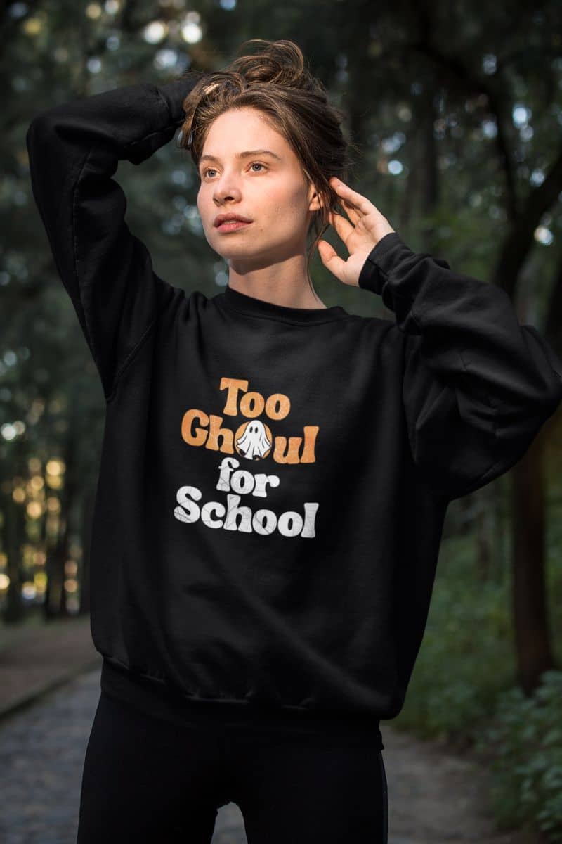 Halloween ghost hoodie with a person wearing a black sweatshirt with 'Too Ghoul for School' text in an outdoor setting