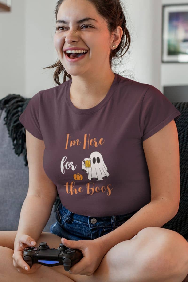 Halloween graphic tee featuring a girl in a brown T-shirt with the text “I’m Here for the Boos”, playing a game