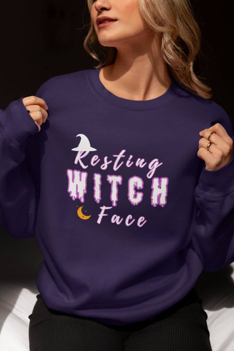 Halloween witch sweater with a person featuring a purple sweatshirt with 'Resting Witch Face' text and graphics.