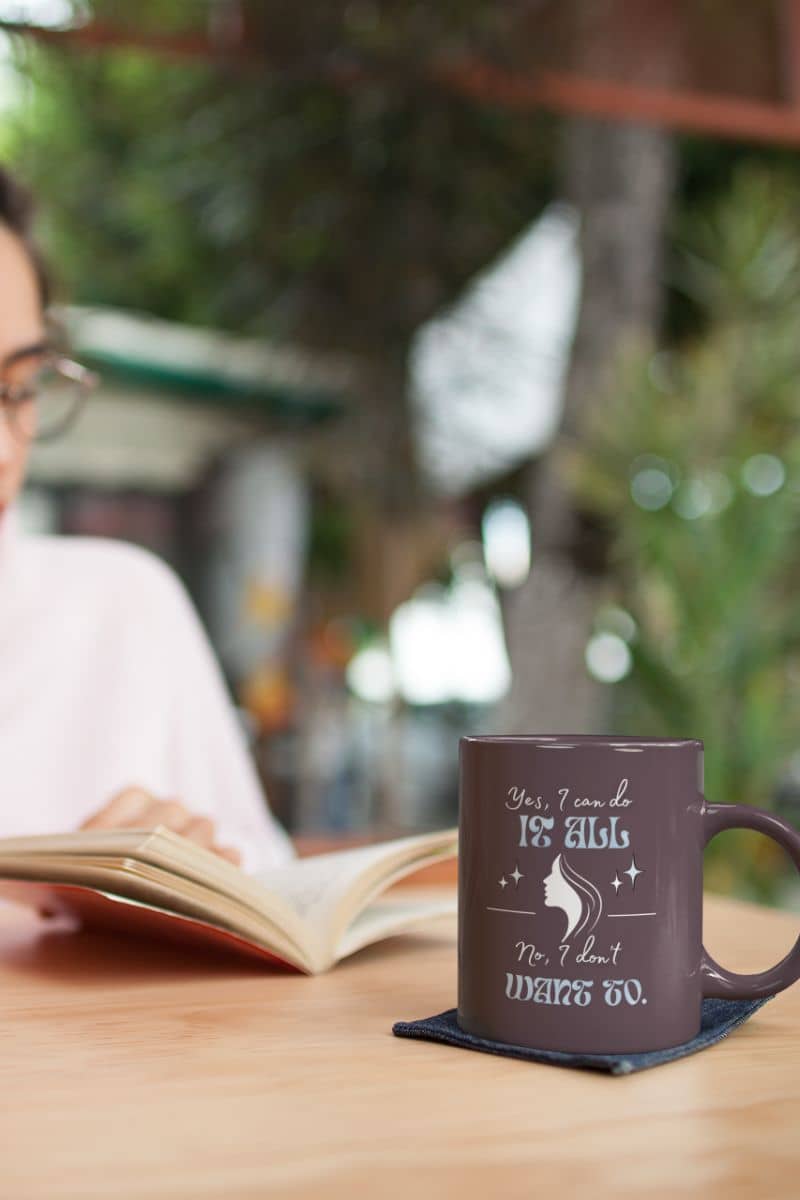 Hilarious coffee mug with a young girl reading a book next to a cup of coffee on the table