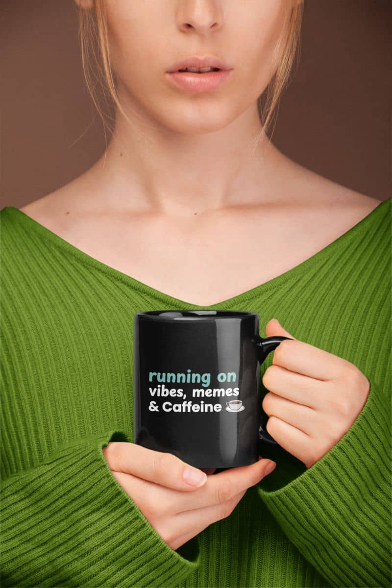 I run on coffee mug with a person holding a black mug with text, wearing a green sweater against a brown background