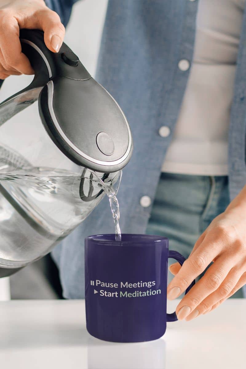 Inner peace ceramic mug with a person pouring water from a kettle into a purple mug with text.