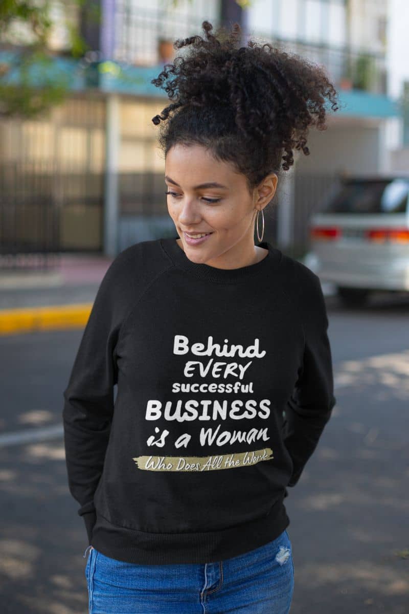 Inspirational sweatshirts with a curly haired woman standing with her hands behind her back and looking to one side