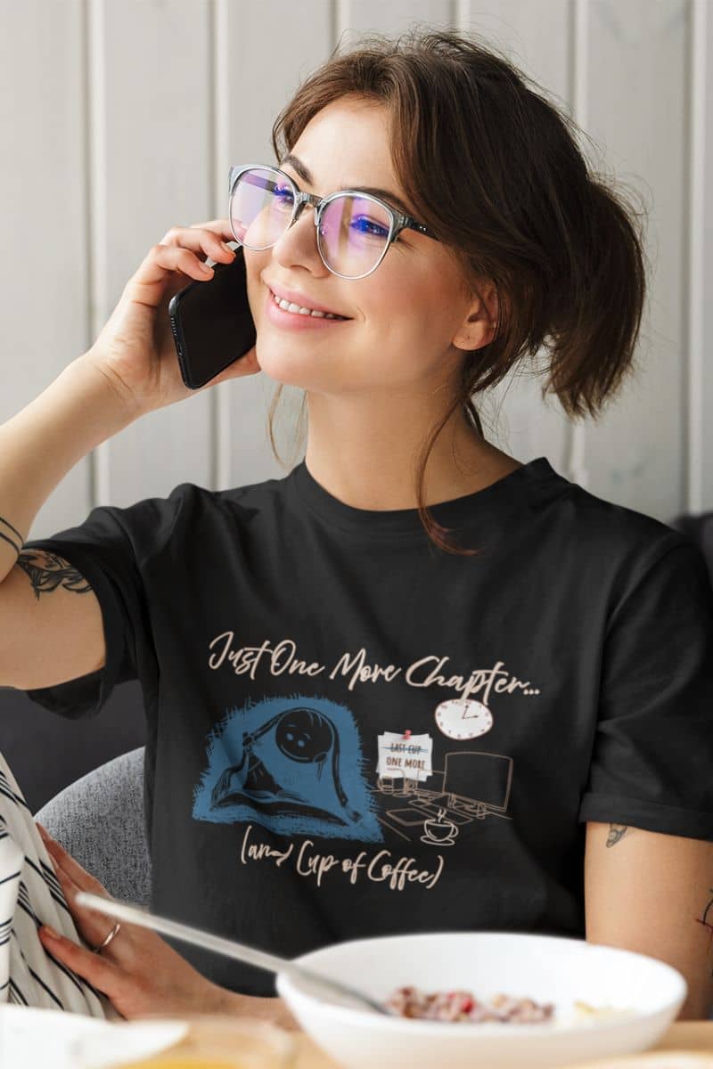 Just one more chapter t-shirt with a girl talking on the phone while eating breakfast with a book on the dining table