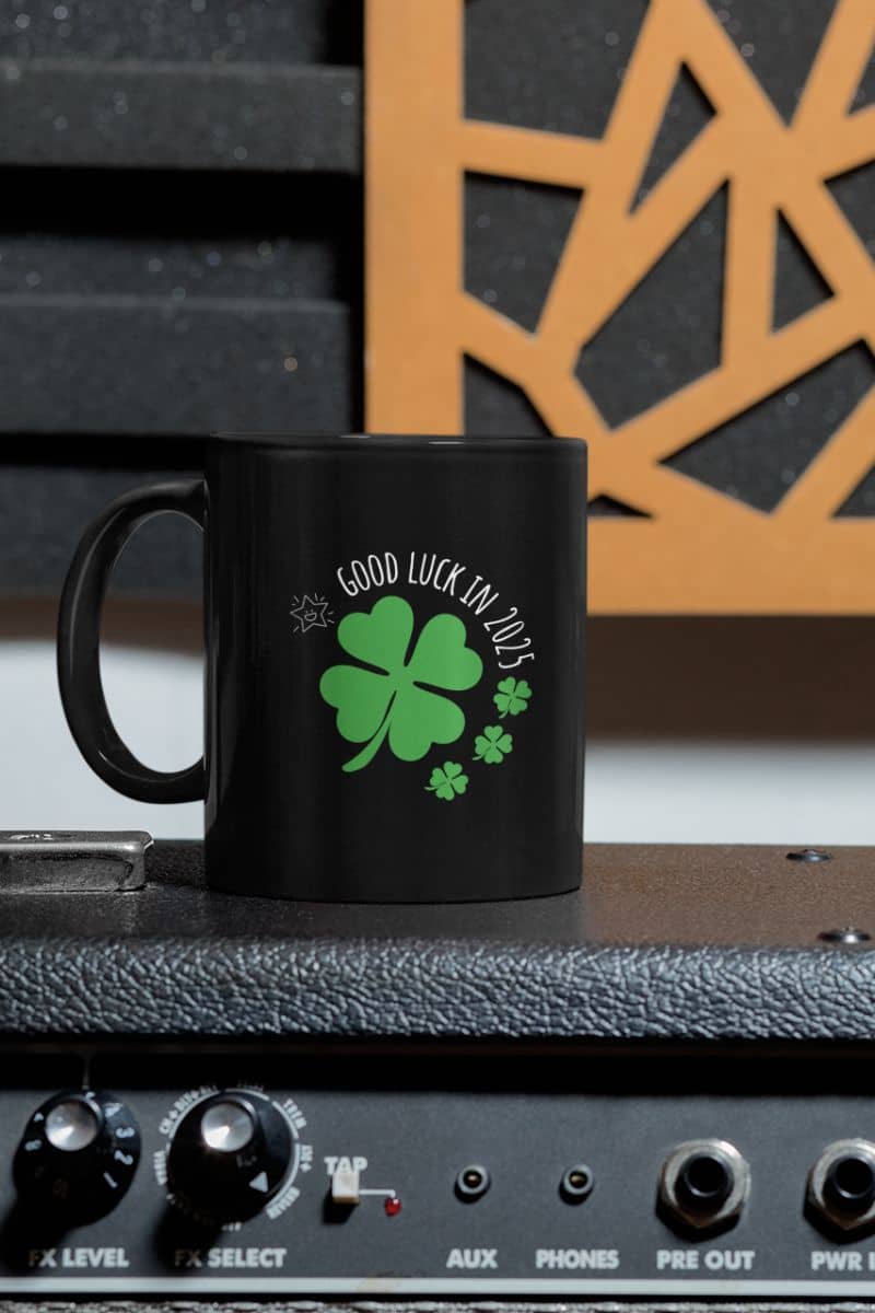 Lucky Charm 11 oz Mug with a cup lying on the sound system