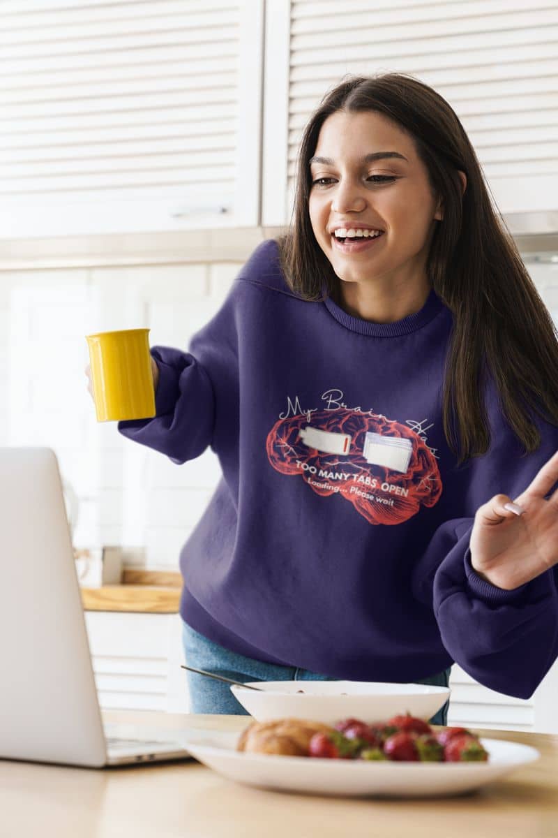 Mental overload sweatshirt with a young girl raising her hand in greeting while attending an online class