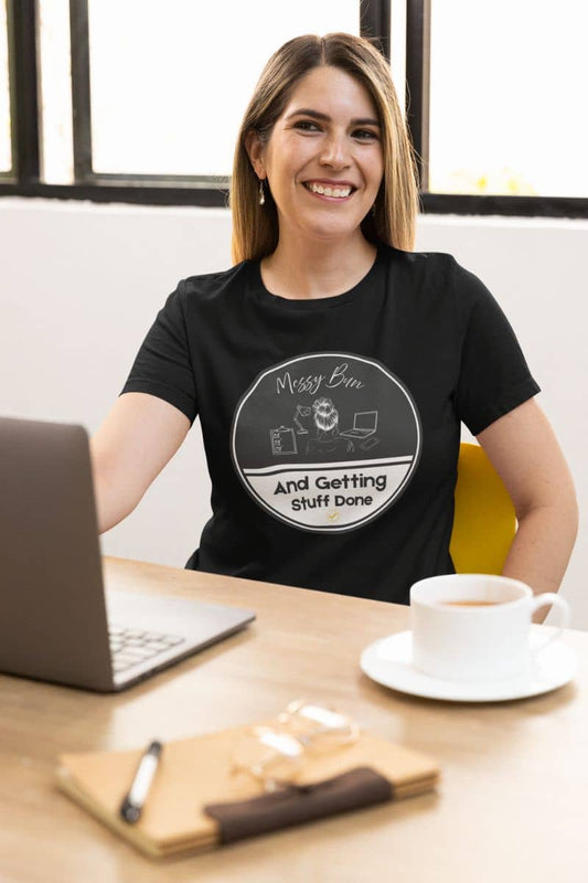 Messy bun t-shirt with the girl sitting smiling brightly at her desk