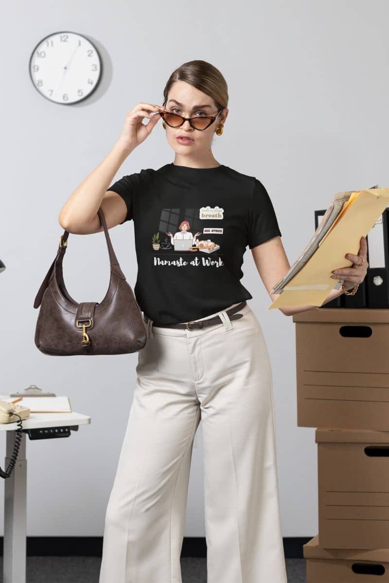 Mindfulness shirt for office workers with a girl standing in the office posing with a stack of papers and a bag in her hand
