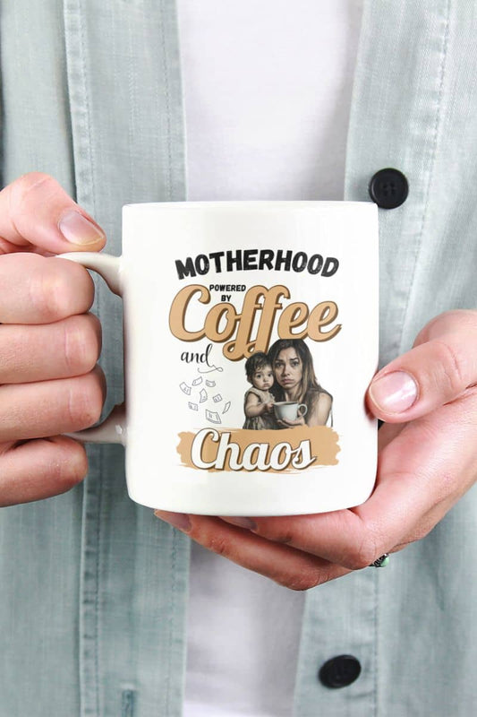Mom life coffee mug with a person holding a mug with 'Motherhood: powered by Coffee and Chaos' text and a photo of a woman and child.