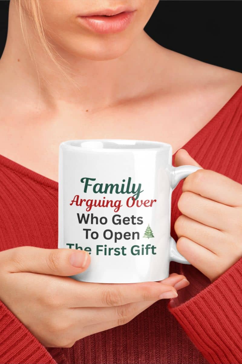 Morning coffee Christmas mug with a person holding a white mug with text 'Family: Arguing Over Who Gets To Open The First Gift'